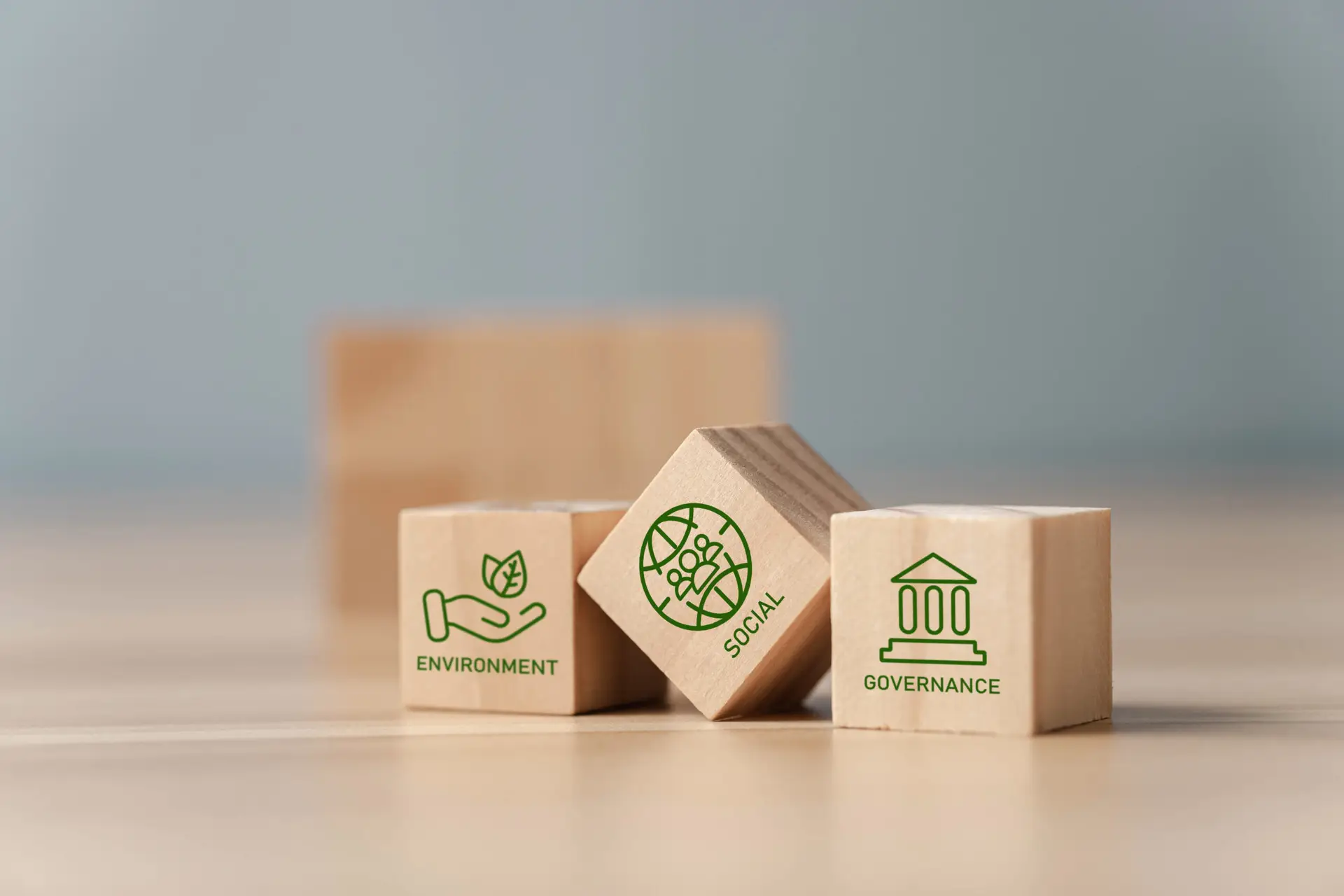 ESG represented by Environmental, Social and Governance wooden blocks, where one block is skewed to represent issues with standardization in ESG reporting