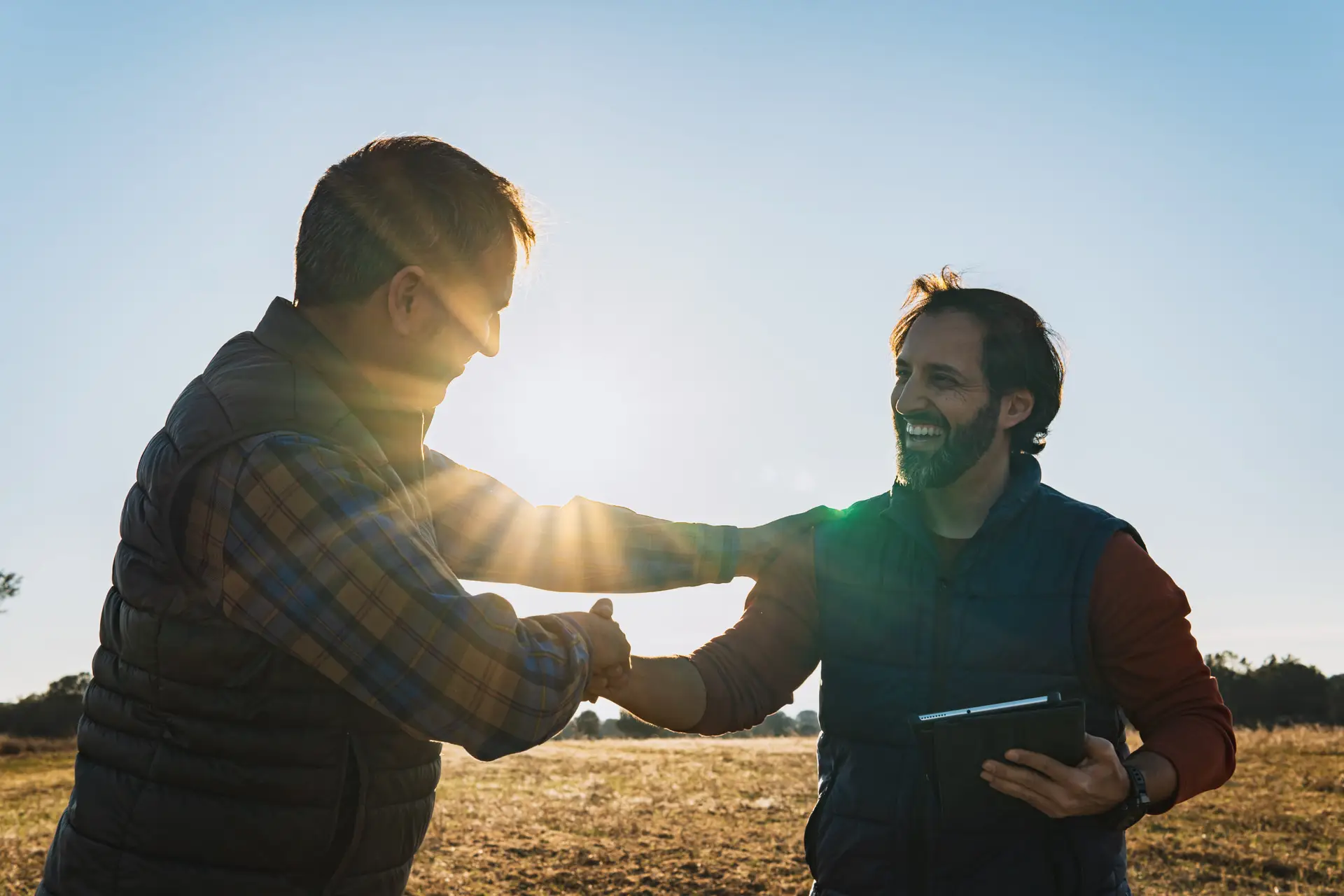 Two professionals shaking hands outdoors after working with an operational excellence consultant to improve business outcomes
