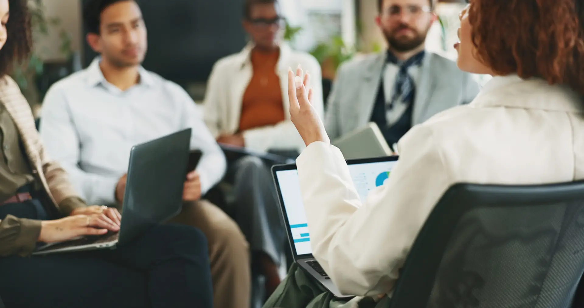 Businesswoman leading team discussion on risk management and compliance during a financial planning meeting.