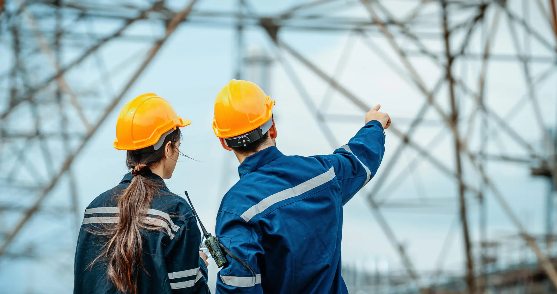 Engineers inspecting power lines and discussing safety protocols at an electrical substation, backed by Engage Advisors' guidance.
